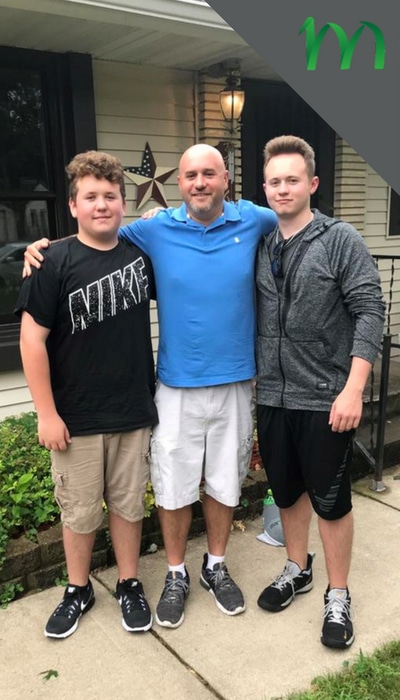 Jeremy Bruce, the owner of Midwest Lawn Pro stands in his front yard with his two sons.